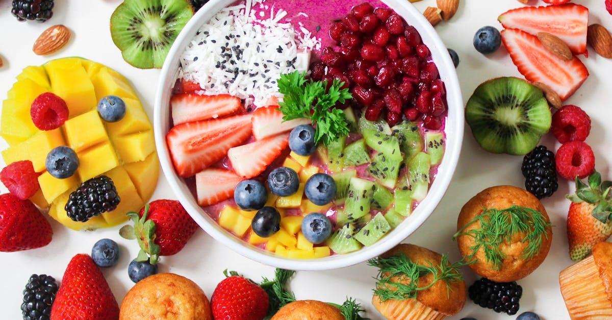 Vibrant smoothie bowl topped with assorted fresh fruits and muffins, perfect for a healthy snack.